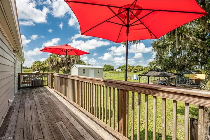 Deck featuring an outbuilding, a gazebo, and lawn
