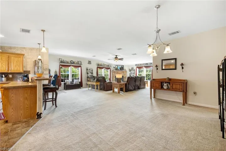 Carpeted living room featuring ceiling fan