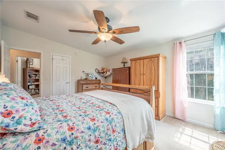 Bedroom with light carpet, a closet, and ceiling fan