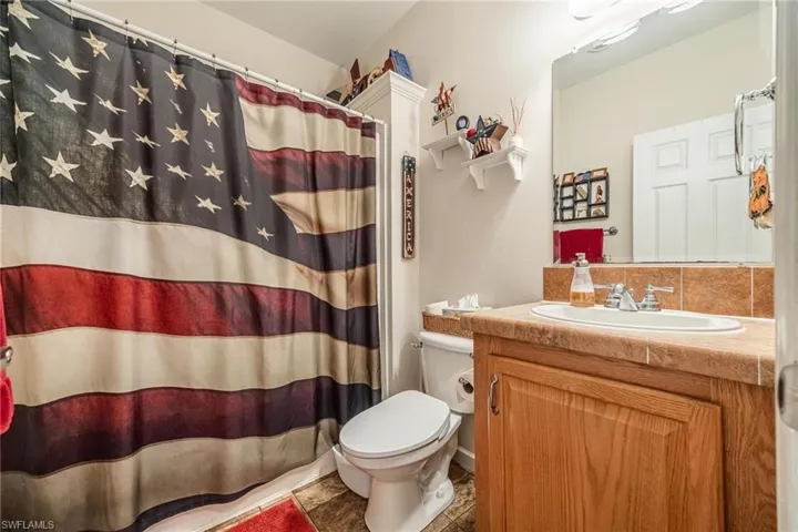 Bathroom with vanity, toilet, and tile patterned flooring