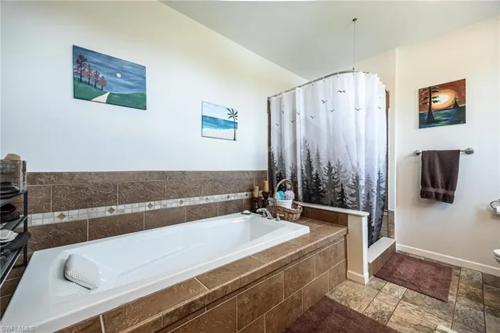 Bathroom featuring a relaxing tiled tub and tile patterned flooring