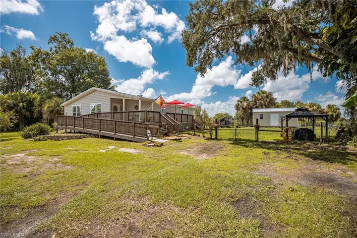 View of yard and home featuring a deck