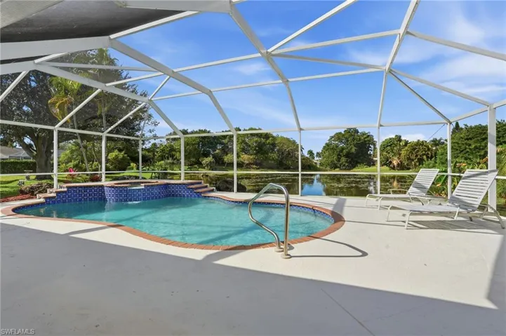 Integrated pool / spa featuring a sunroom, glass enclosure, a patio area, and view of scattered trees