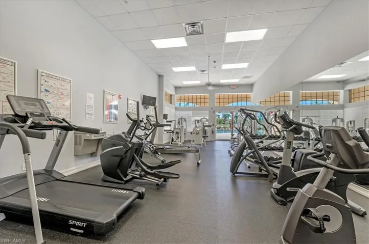 Exercise room with a high ceiling, plenty of natural light, and a paneled ceiling