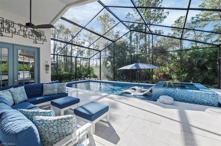 View of swimming pool with outdoor lounge area, glass enclosure, ceiling fan, and a patio area