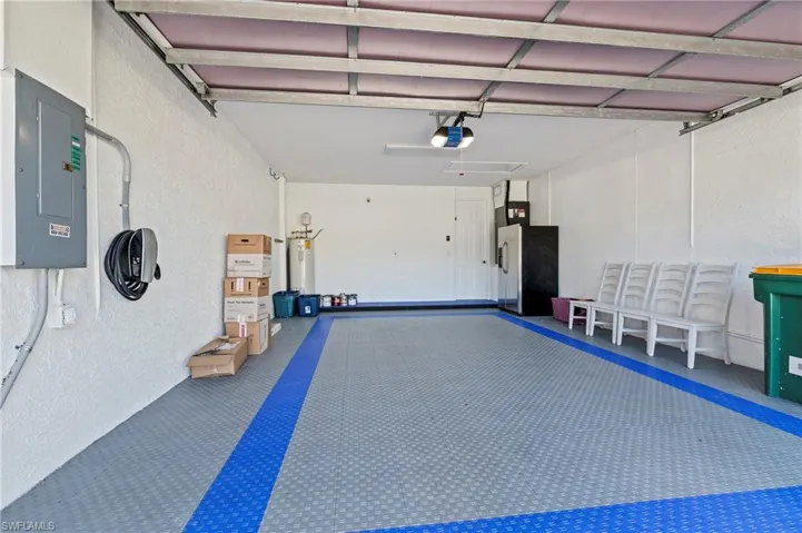 Garage featuring electric panel and a garage door opener
