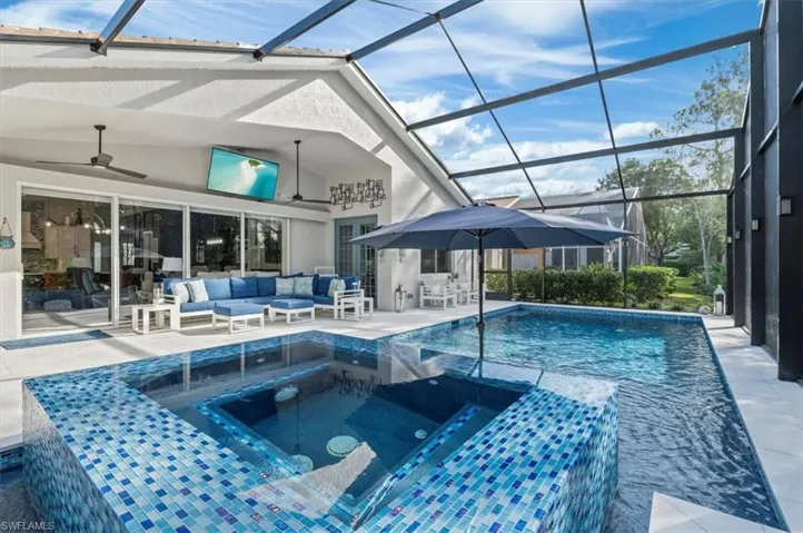 View of swimming pool with an in ground hot tub, a patio area, ceiling fan, a lanai, and an outdoor living space