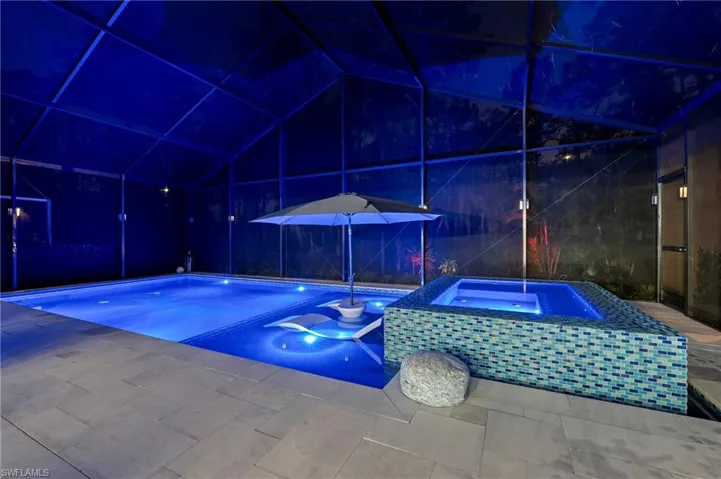 View of pool featuring a patio, a lanai, and an in ground hot tub