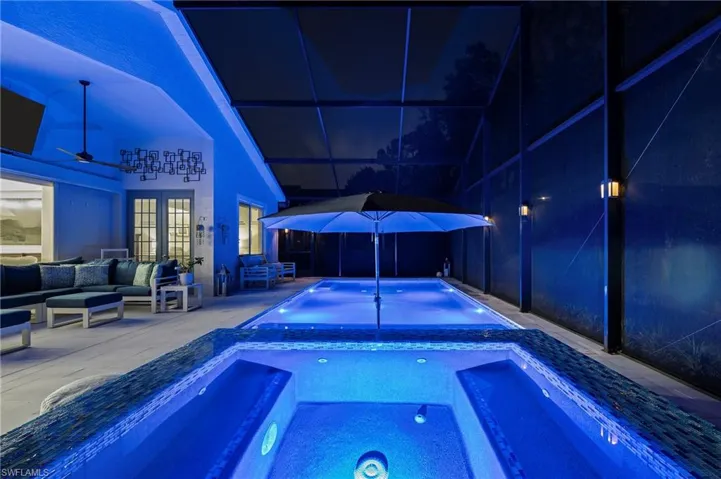 View of pool with an outdoor hangout area, a patio, a lanai, and an in ground hot tub