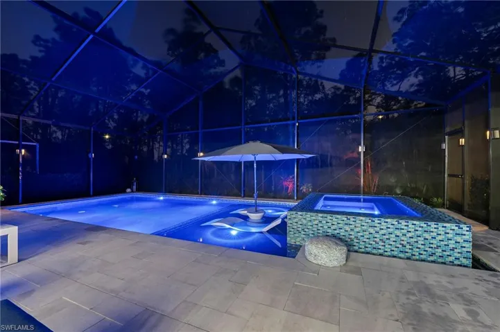 View of pool with a lanai, a patio, and an in ground hot tub