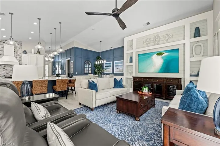 Living room with ceiling fan and built in shelves