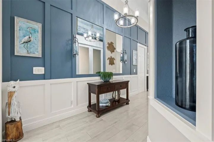 Foyer entrance with light wood-type flooring and a chandelier