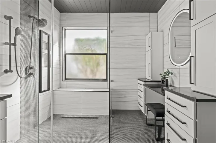 Bathroom with vanity and tiled shower