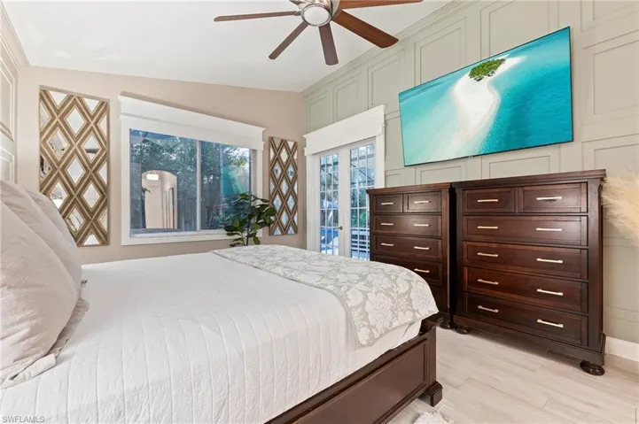 Bedroom with light wood-type flooring, access to outside, ceiling fan, and vaulted ceiling