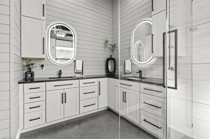 Bathroom featuring vanity, tile patterned flooring, and a shower with shower door