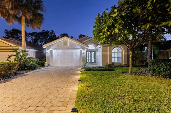 View of front facade with a garage and a yard