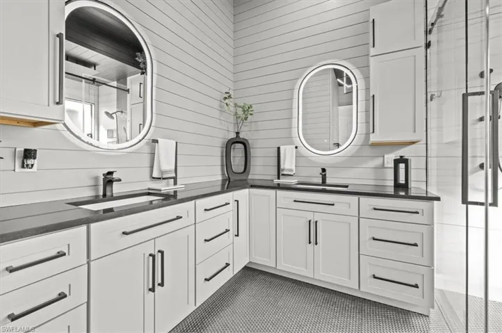 Bathroom featuring vanity, an enclosed shower, and tile patterned flooring