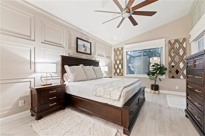 Bedroom featuring ceiling fan, light wood-type flooring, and lofted ceiling
