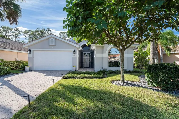 Single story home with a garage and a front lawn