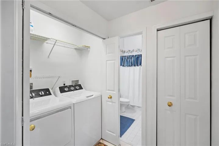 Laundry area featuring independent washer and dryer and tile patterned floors