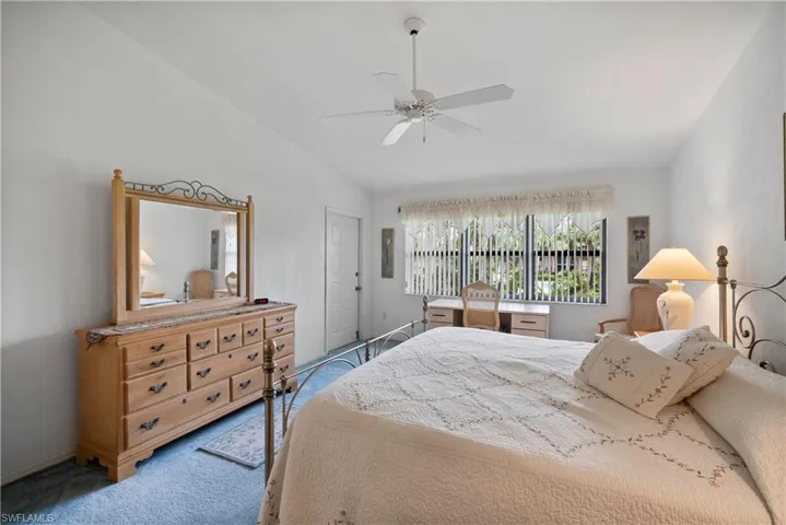 Bedroom featuring ceiling fan, carpet, and vaulted ceiling