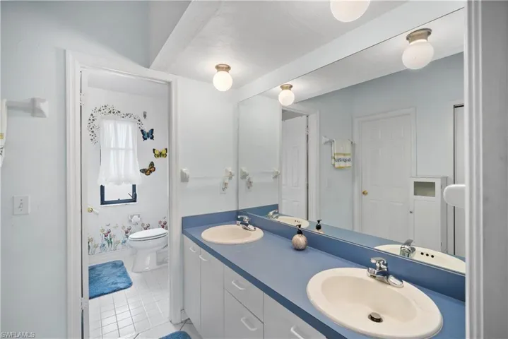 Bathroom featuring toilet, vanity, and tile patterned floors