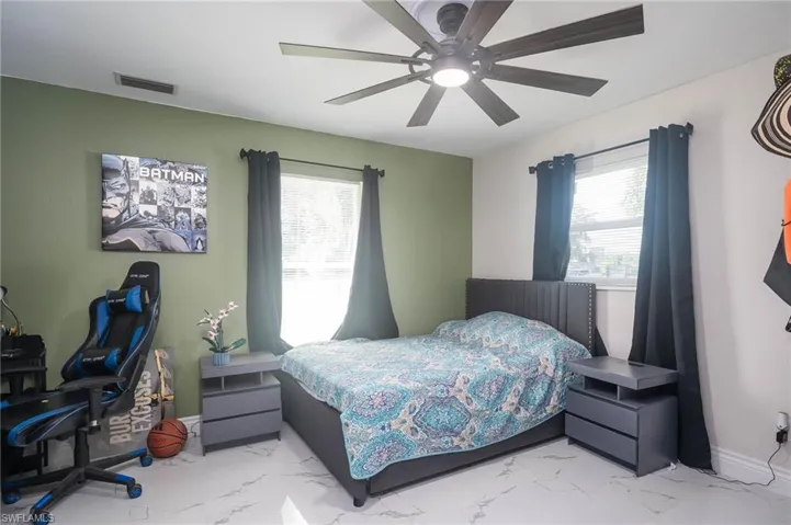 Bedroom with multiple windows and ceiling fan