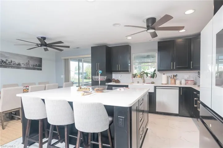 Kitchen featuring dishwasher, a center island, and a kitchen bar