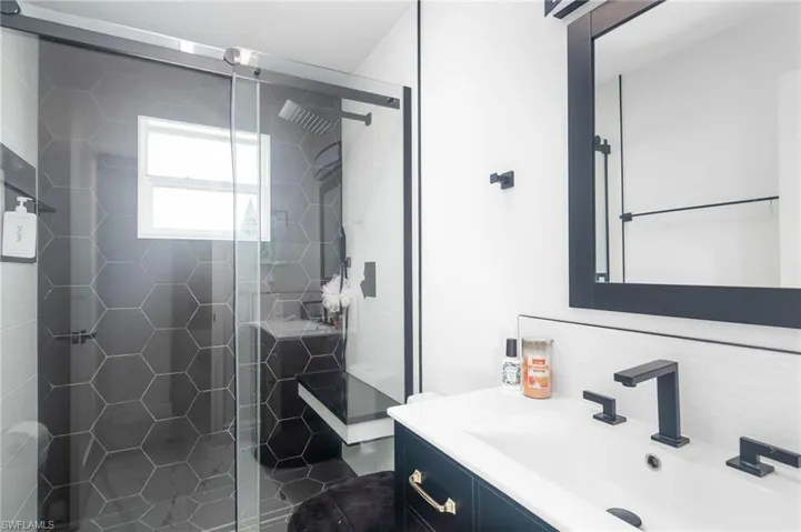 Bathroom featuring a shower with door and vanity