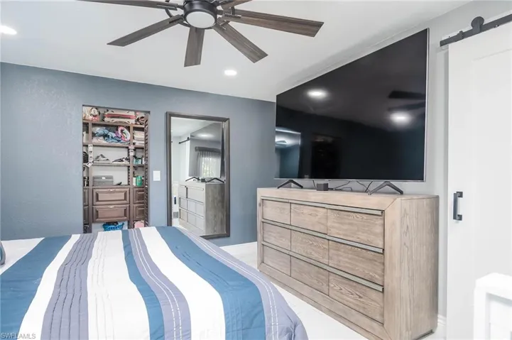 Bedroom featuring ceiling fan and a barn door