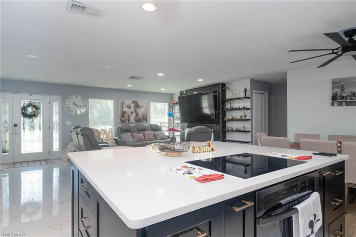 Kitchen with a kitchen island, ceiling fan, and black appliances
