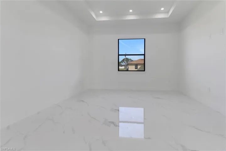 Unfurnished room with a raised ceiling