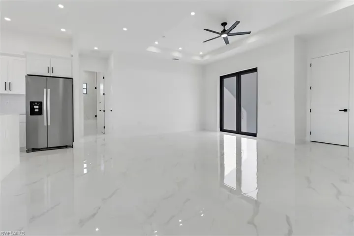 Empty room with ceiling fan and a tray ceiling