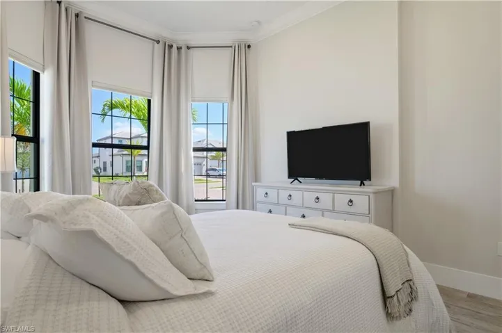 Bedroom featuring wood finished floors and ornamental molding
