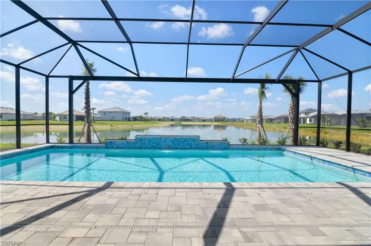 Outdoor pool with glass enclosure, a residential view, and a patio