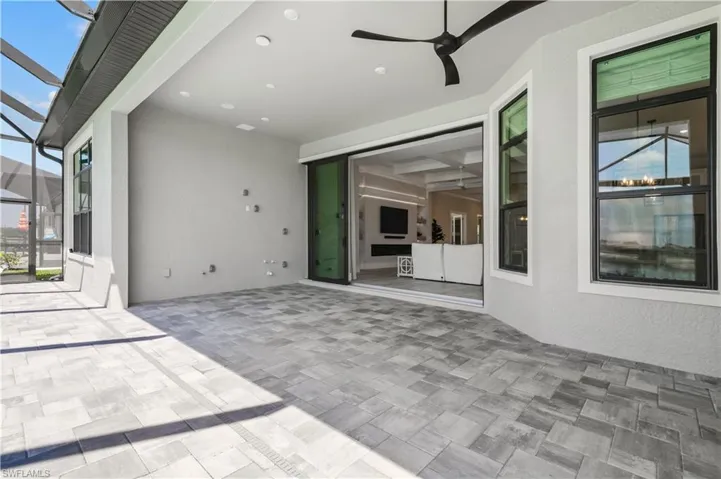 View of patio with glass enclosure and ceiling fan