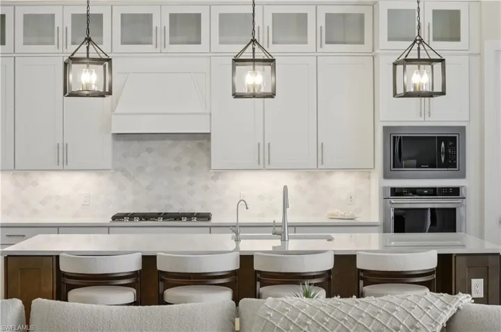 Kitchen featuring stainless steel appliances, light countertops, and a breakfast bar