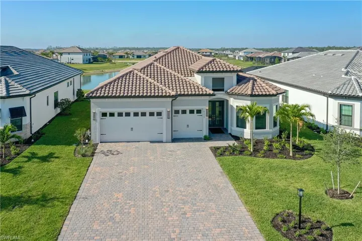 Mediterranean / spanish-style home featuring a residential view, an attached garage, decorative driveway, and stucco siding