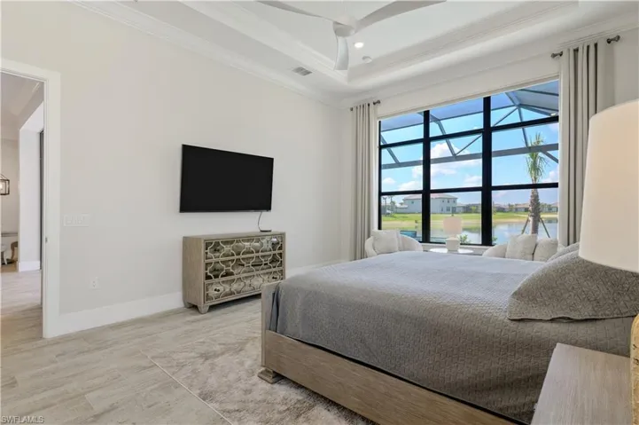 Bedroom with crown molding, a raised ceiling, wood finished floors, and recessed lighting
