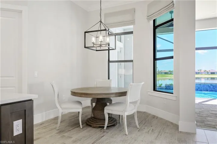 Dining area featuring a chandelier, light wood-type flooring, crown molding, and a water view