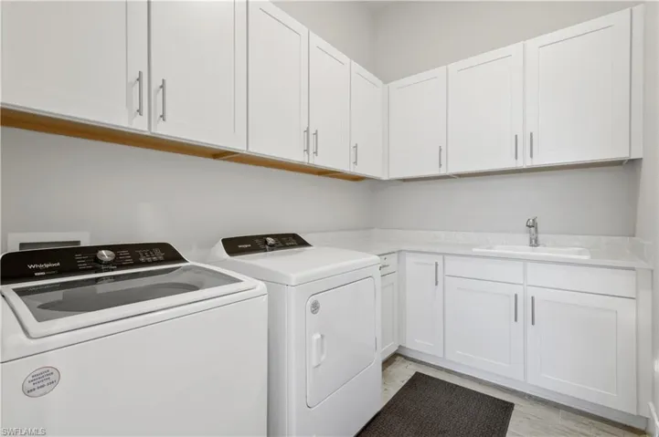 Laundry area with separate washer and dryer and cabinet space