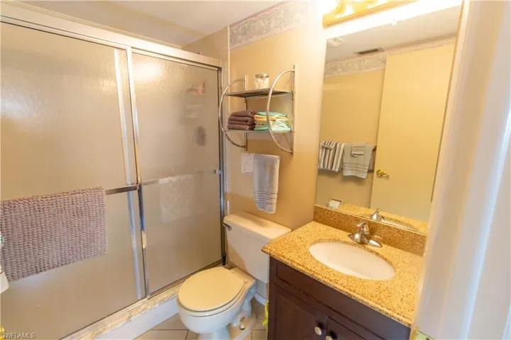 Full bath with a shower stall, vanity, and tile patterned floors