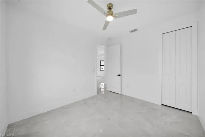 Unfurnished bedroom featuring a ceiling fan and a closet