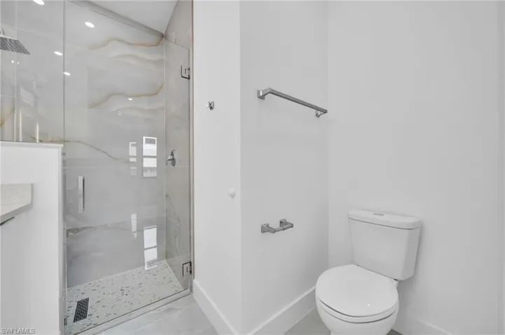 Full bathroom featuring a marble finish shower and tile patterned flooring