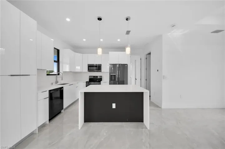 Kitchen featuring a center island, modern cabinets, white cabinets, pendant lighting, and appliances with stainless steel finishes
