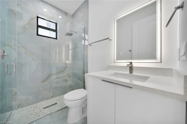 Bathroom with a marble finish shower and vanity