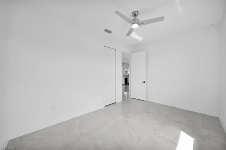 Spare room with ceiling fan and baseboards