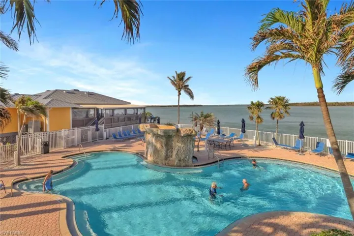 Community pool featuring a deck and view of bay