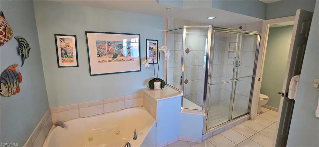 Full bath featuring a jetted tub, a stall shower, light tile patterned floors, and recessed lighting