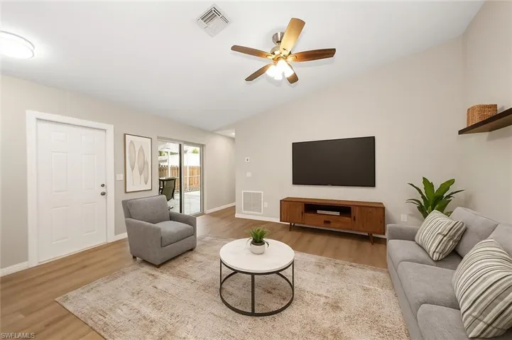 Living area featuring vaulted ceiling, wood finished floors, and a ceiling fan